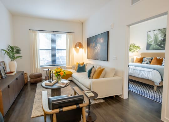 a living room with a couch and a chair and a bedroom with a bed  at La Unión, Tampa, FL