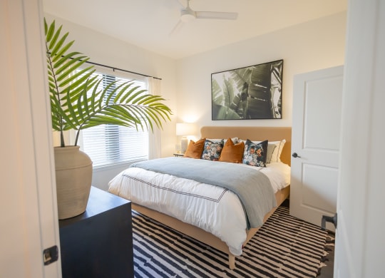 a bedroom with a bed and a potted plant  at La Unión, Tampa, FL, 33605