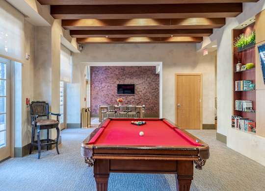 A pool table is in the middle of a room with a chair and a window at Garfield Park, Arlington, 22201