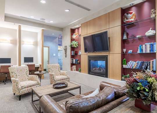 A living room with a brown leather couch, a coffee table, and a television at Garfield Park, Arlington, 22201