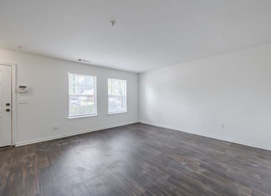 an empty living room with wood floors and white walls at Greens at Stonecreek, Lithonia, 30038