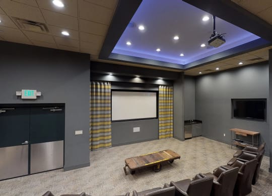 a large room with a projector screen and chairs at The Gunther, Maryland, 21224