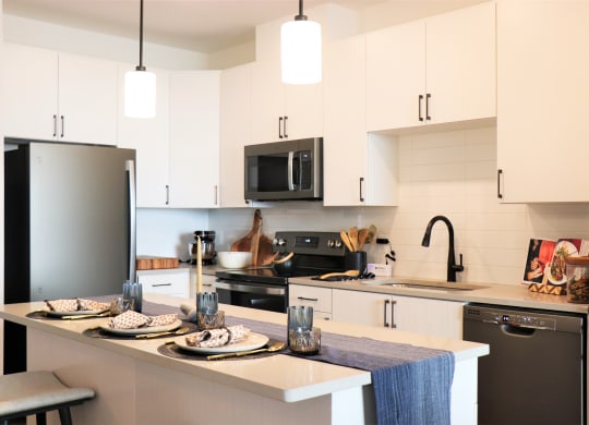 a kitchen with white cabinets and black appliances at Vyne One Loudoun, Virginia, 20147
