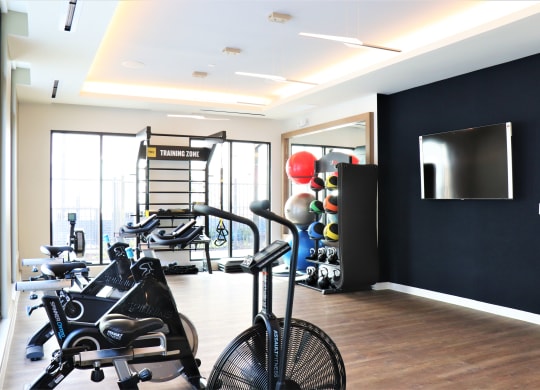 a gym with exercise equipment and a flat screen tv on the wall at Vyne One Loudoun, Virginia