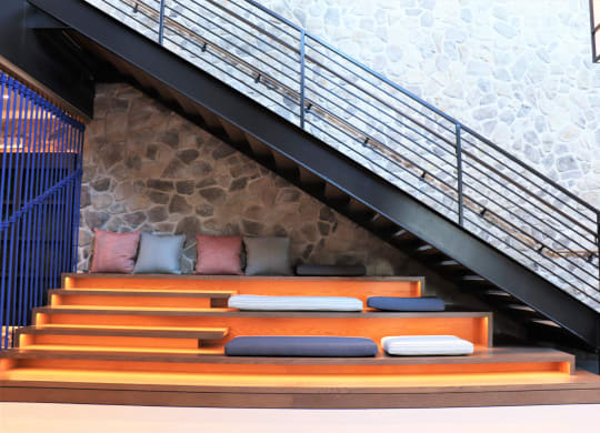 a bench with pillows under the stairs at Vyne One Loudoun, Ashburn, Virginia