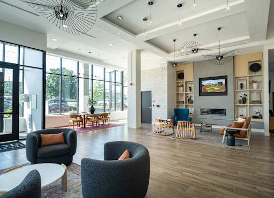 A modern living room with a television, a fireplace, and a large window.