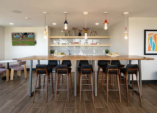 A bar area with a long wooden table and chairs.