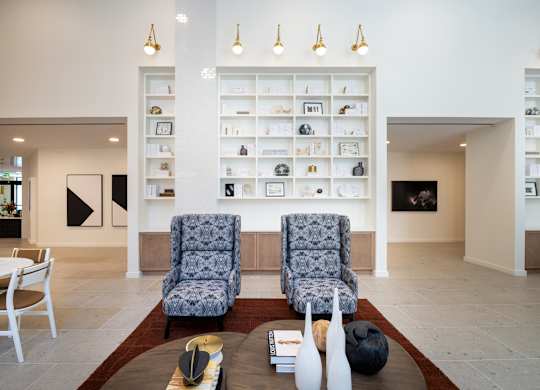 Two chairs sit on a rug in front of a wall of shelves at The Sully Apartments, Chantilly, Virginia