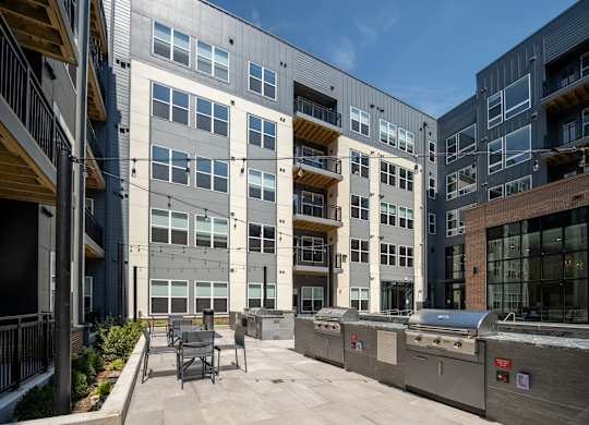A modern building with a patio and outdoor furniture at The Sully Apartments, Virginia