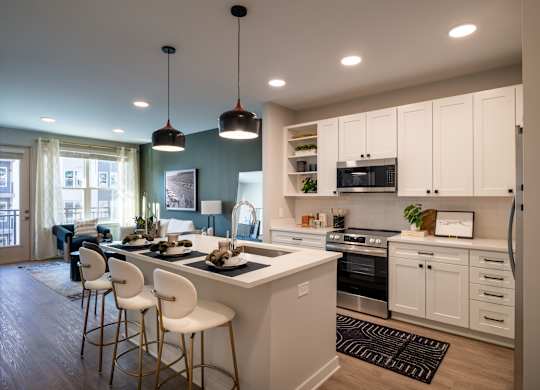 A modern kitchen with white cabinets and a large island.at The William, Virginiaa, 20152
