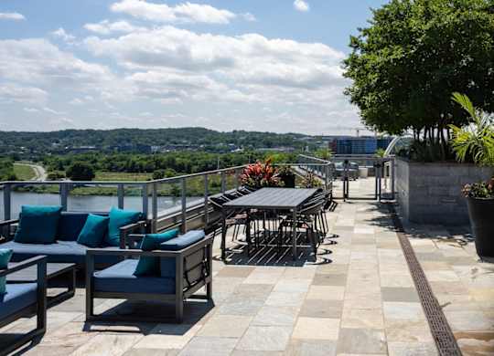 A patio with tables and chairs overlooking a river. at Dock 79, District of Columbia, 20003