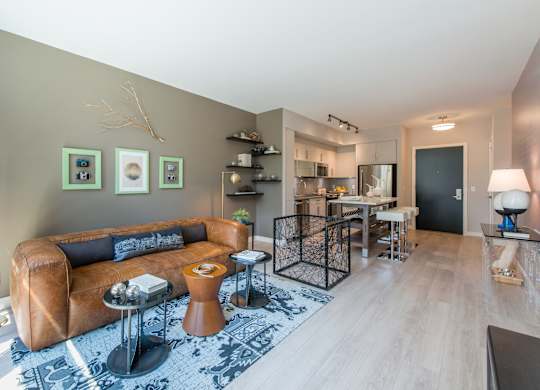 A living room with a brown leather couch and a coffee table. at Dock 79, Washington
