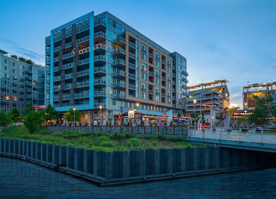 A modern building with a green roof is situated next to a body of water. at Dock 79, Washington, District of Columbia