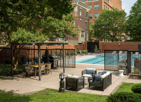 a swimming pool with chairs and tables in a courtyard