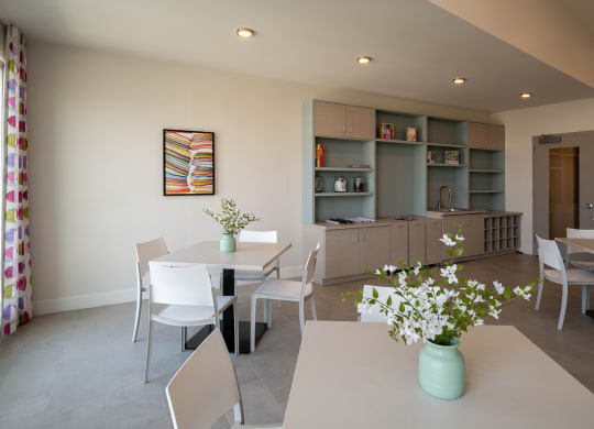 a room with a table and chairs and a kitchen in the background  at Woodmore Grand, Bowie, MD, 20721