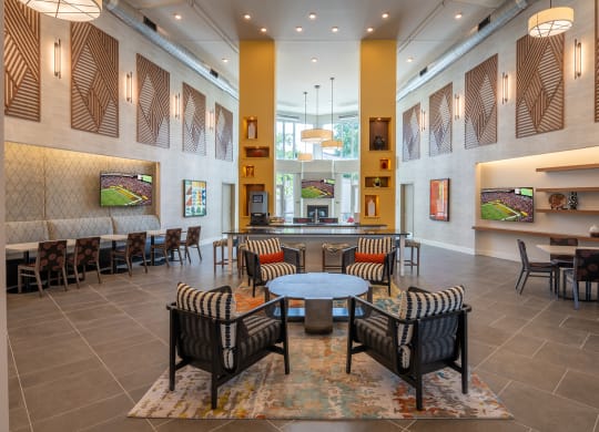 a seating area with tables and chairs in the atrium of a building  at Woodmore Grand, Bowie