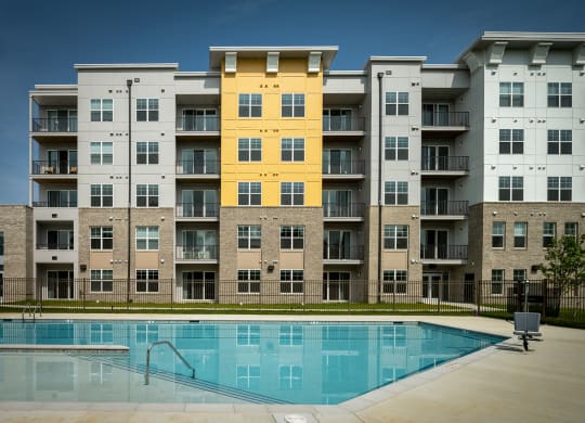 an image of an apartment building with a swimming pool  at Woodmore Grand, Bowie, MD, 20721