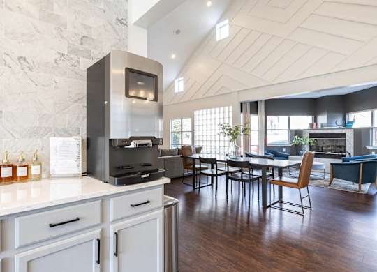A modern kitchen with a stone wall and a dining table with chairs.at Crestline Cary, North Carolina
