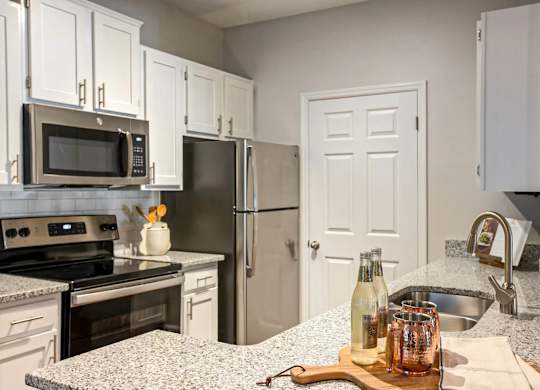 A kitchen with a granite countertop and a white refrigerator.at Crestline Cary, North Carolina, 27511