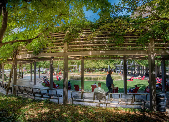 a group of people sitting on benches in a park at The Acadia at Metropolitan Park, Virginia