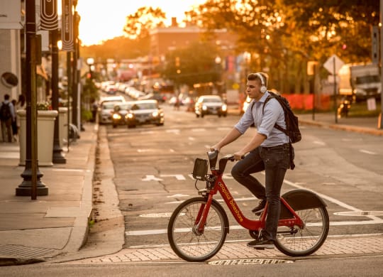 a man riding a bike on a city street at The Acadia at Metropolitan Park, Arlington, VA