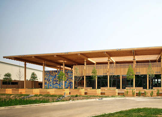 A modern building with a wooden exterior and a large mural on the side.at The Residences at St. Elizabeths East, Washington, DC 20032