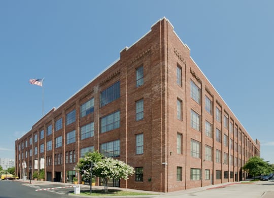 a large brick building with an flag in front of it at Tindeco Wharf, Baltimore