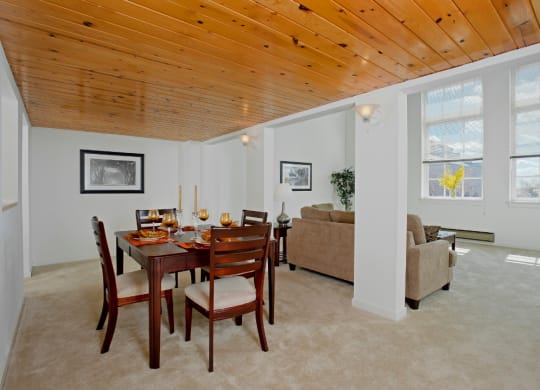 a dining room with a wooden ceiling and a table and chairs at Tindeco Wharf, Baltimore Maryland