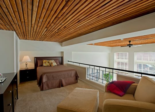 a bedroom with a bed and a couch and a balcony at Tindeco Wharf, Maryland