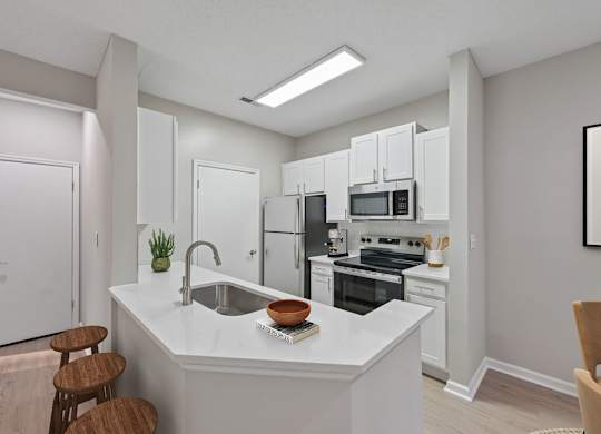 A kitchen with white cabinets and appliances, a sink, and a counter with a bowl and a book on it.