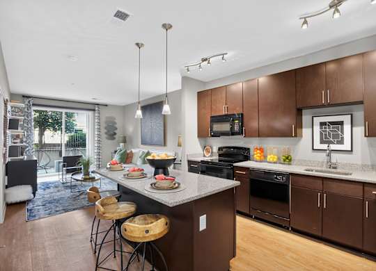 A modern kitchen with brown cabinets and a large island.