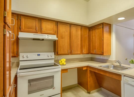 a kitchen with white appliances and wooden cabinets at North Market South Carroll, Frederick