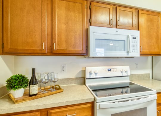 a kitchen with a stove and microwave and wooden cabinets at North Market South Carroll, Frederick