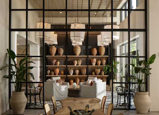 A dining room with a black and white checkered floor and a wooden table with chairs.