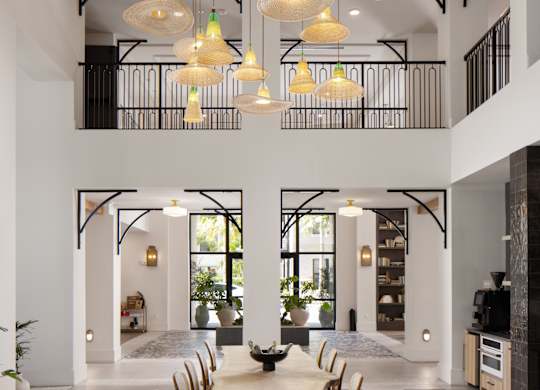 A modern dining room with a checkered floor and a long wooden table.