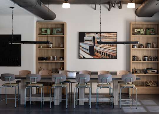 A modern dining room with a large table and chairs.