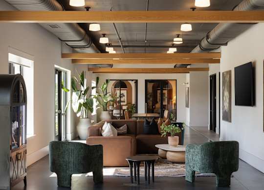 A modern living room with a large couch, two chairs, and a coffee table.