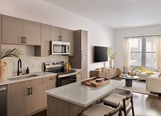 A modern kitchen with a dining area and a living room.