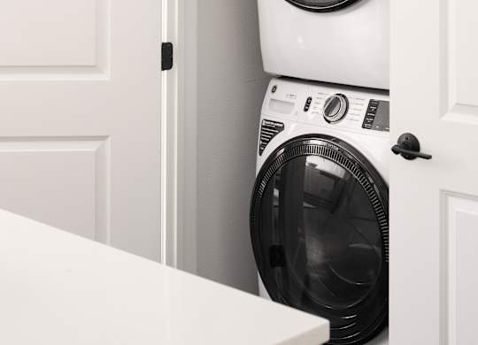 A white washing machine is in a cabinet.