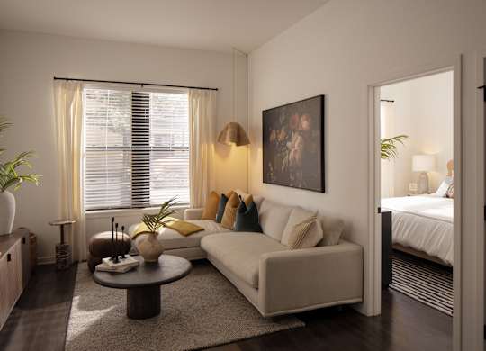A living room with a white couch, a coffee table, and a painting on the wall.