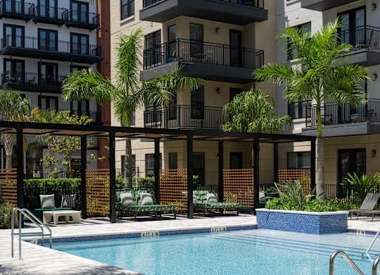 A pool surrounded by a balcony and a building.