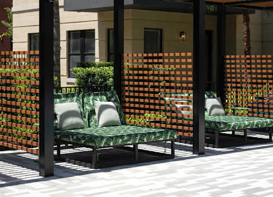 A patio with a bench and a tree.