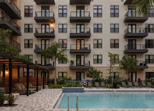 A large apartment complex with a pool in the courtyard.