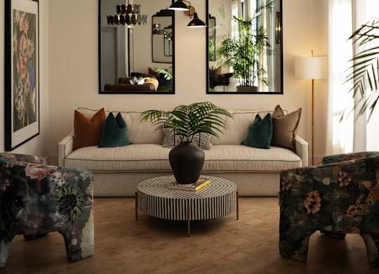 A living room with a white couch, a coffee table, and two large mirrors.