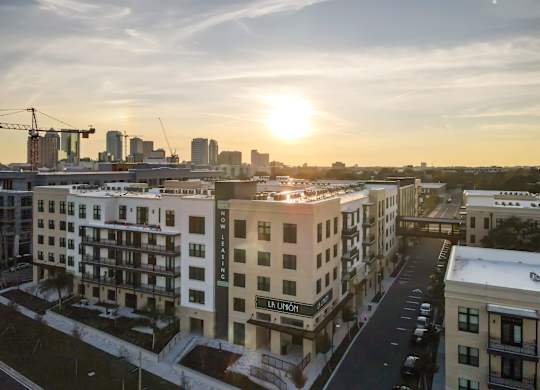 A sunset view of a cityscape with apartment buildings.