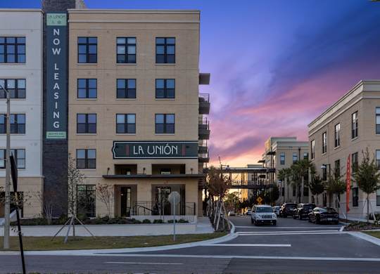 A street view of a building with the sign "La Union" and a car driving by.