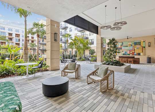 A patio with a table and chairs and a green rug.