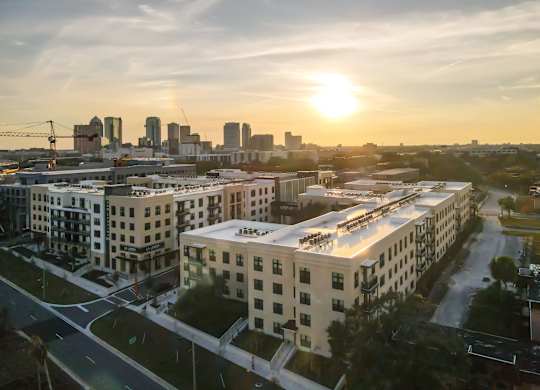 A sunset view of a cityscape with buildings and roads.