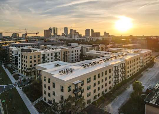 A sunset view of a city skyline with buildings in the foreground.