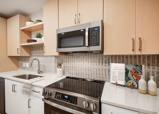 a kitchen with a stove and a microwave at Hawkins Press Apartments, Charlotte